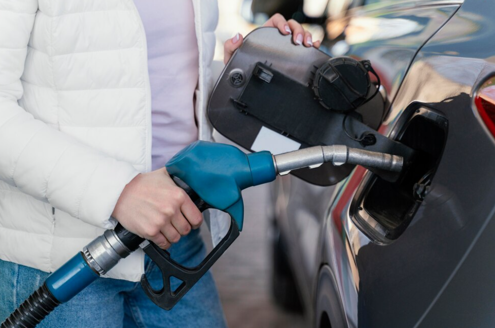 Person refueling car at gas station.